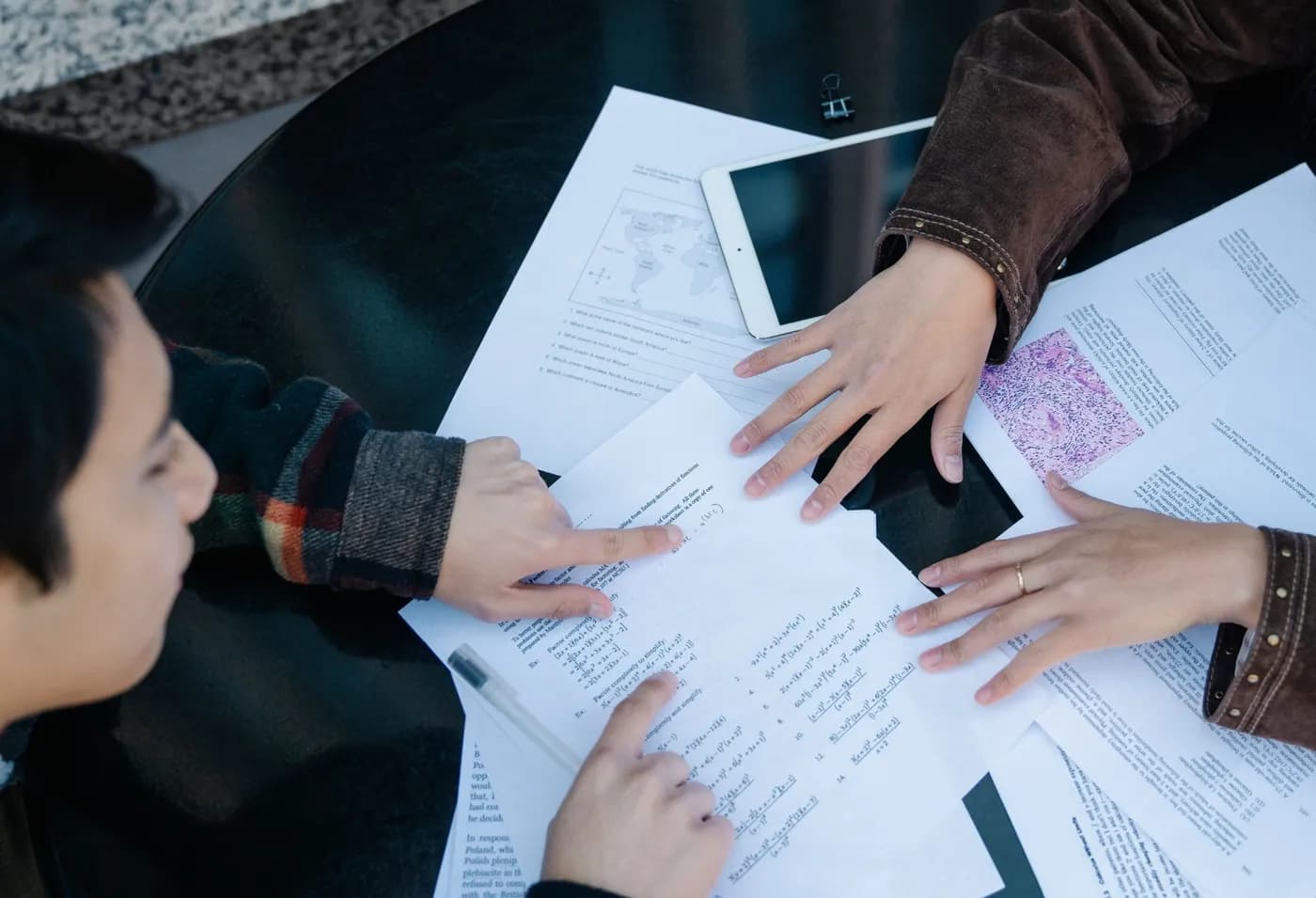 Two students working through practice questions together at a table